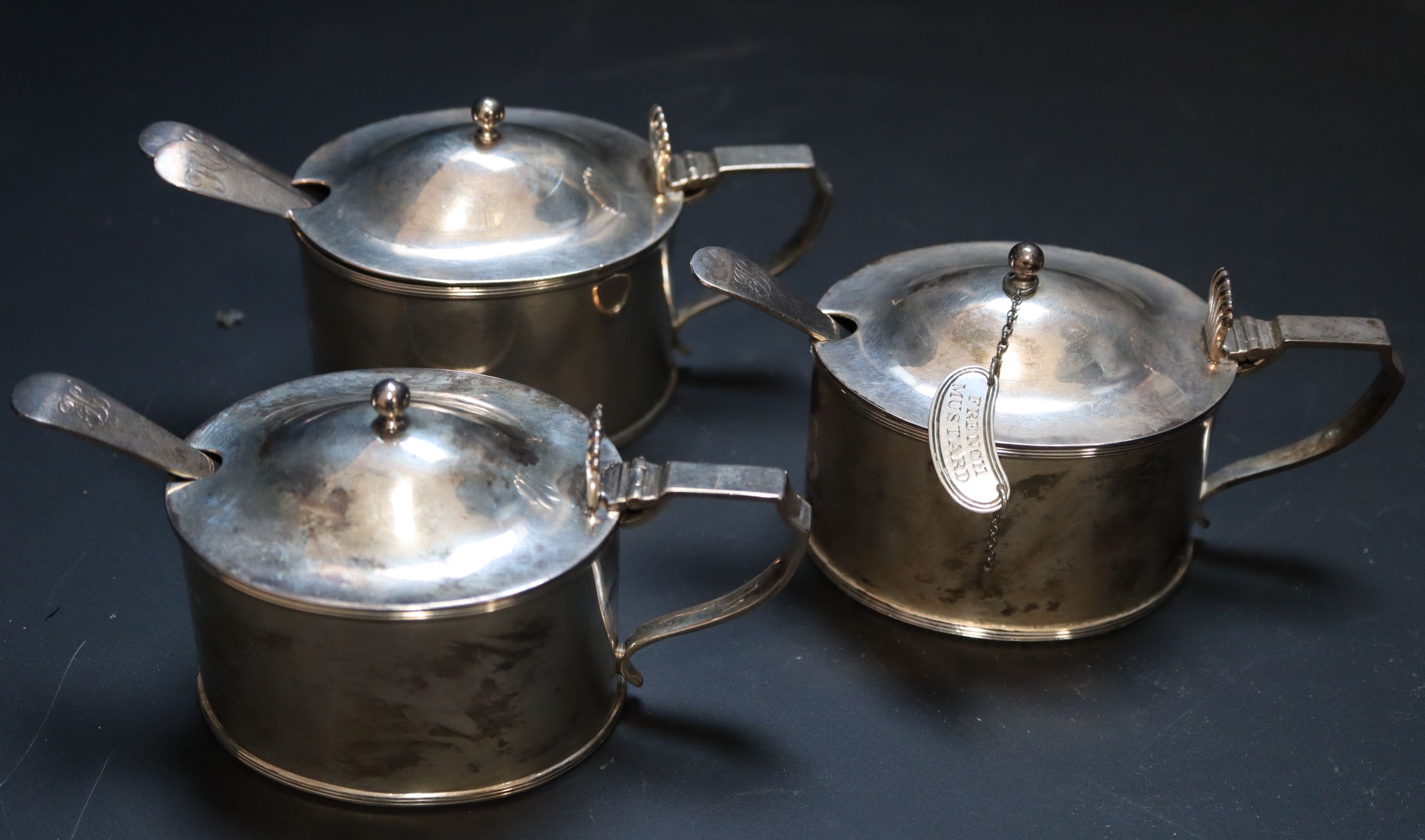 A set of three Edwardian silver mustard pots, gross 16oz.